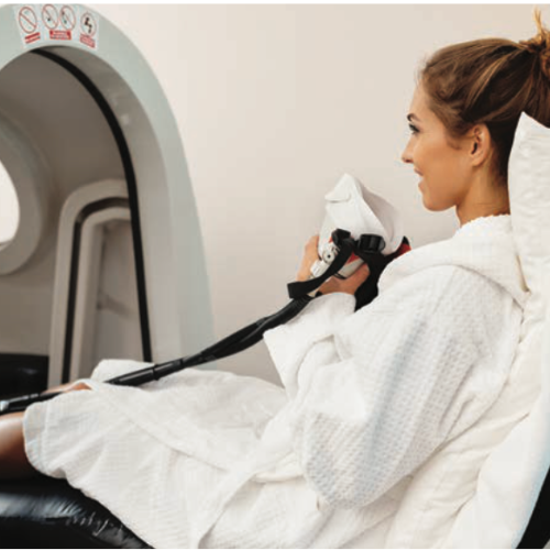 692bafd182f4c57f030f865f (1) Hyperbaric chamber therapy in Miami. Woman wears mask to breathe pure oxygen.