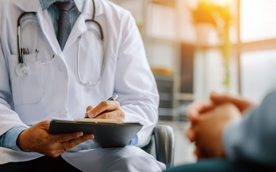 b430b15e-325a-4891-9ceb-f9d358b4a48e Licensed practitioner for regenerative care assesses a patient prior to knee injection appointment.